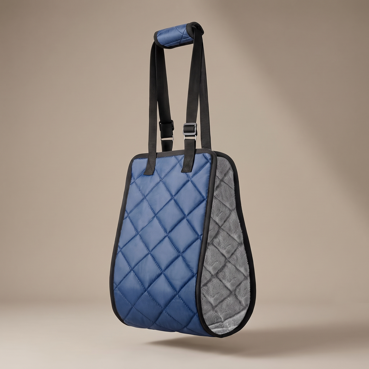The Hup & Up sling hanging by its padded handle, showing the quilted panel and grey plush lining