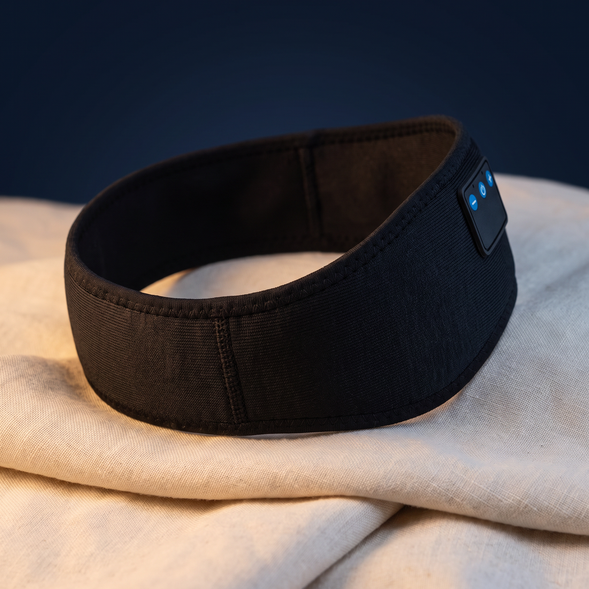 Lullwave Band sleep headphones in black knit fabric on cream linen